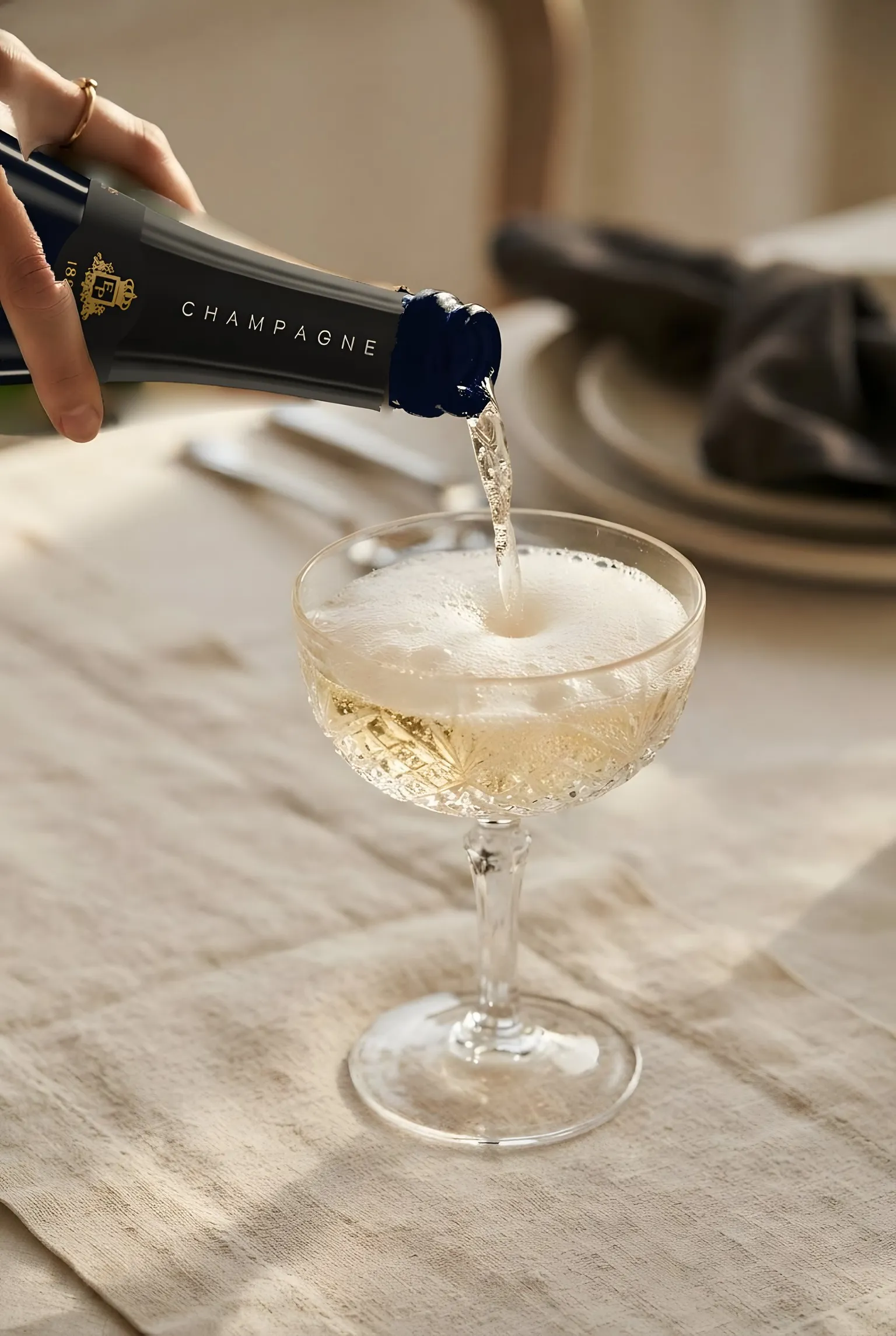 Champagne poured into a coupe, on a linen tablecloth